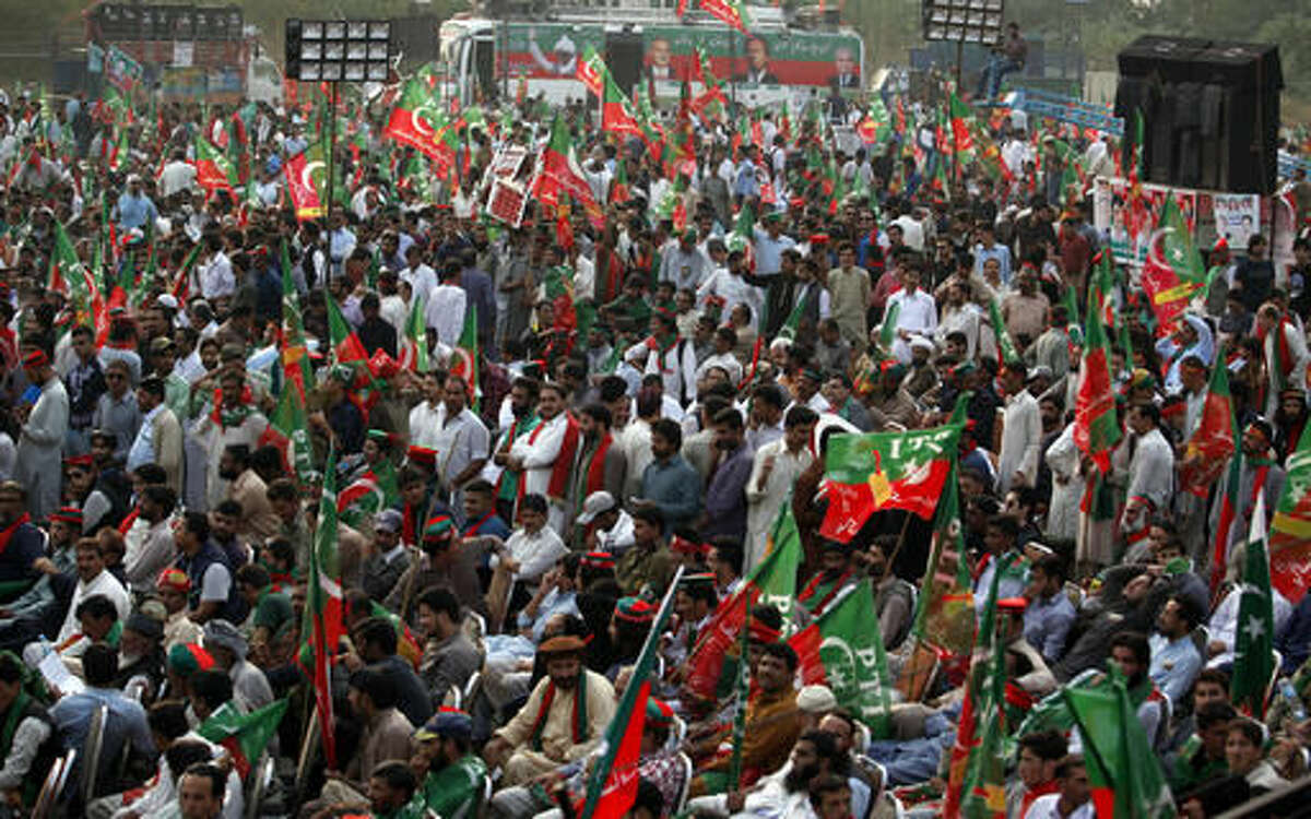 Supporters of a Pakistani opposition party Pakistan Tehreek-e-Isaf wave party flags while taking part in a rally in Islamabad, Pakistan, Wednesday, Nov. 2, 2016. Thousands of supporters of a Pakistani opposition leader gathered in the capital to celebrate a top court's ruling, which asked the primer Nawaz Sharif to submit a written response to allegations that members of his family were holding offshore bank accounts. (AP Photo/Anjum Naveed)