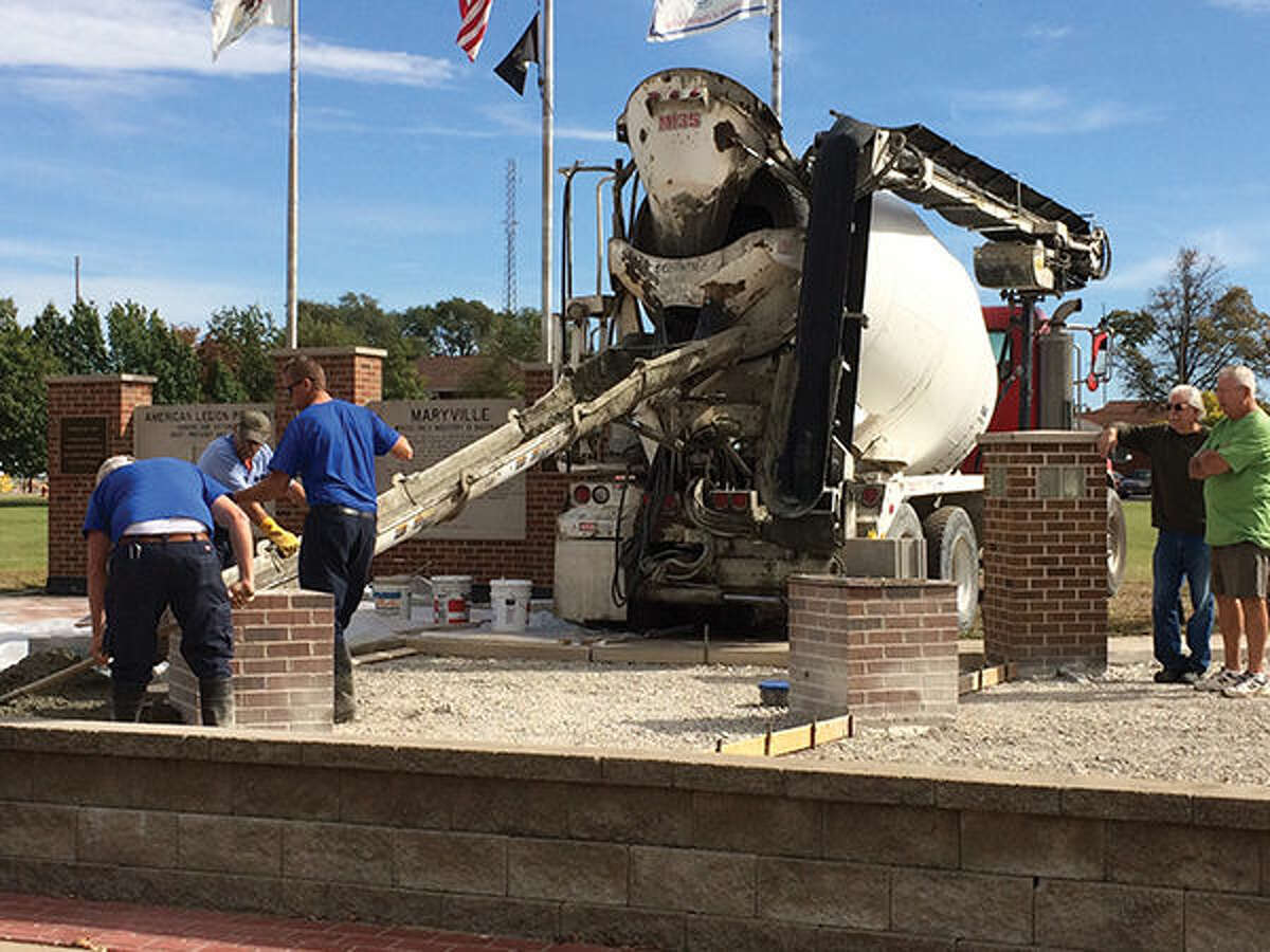 Maryville Trustee Ed Kostyshock, second from right, and project spearhead Joe Semanisin, far right, watch as concrete is poured into the Maryville Memorial on Monday.