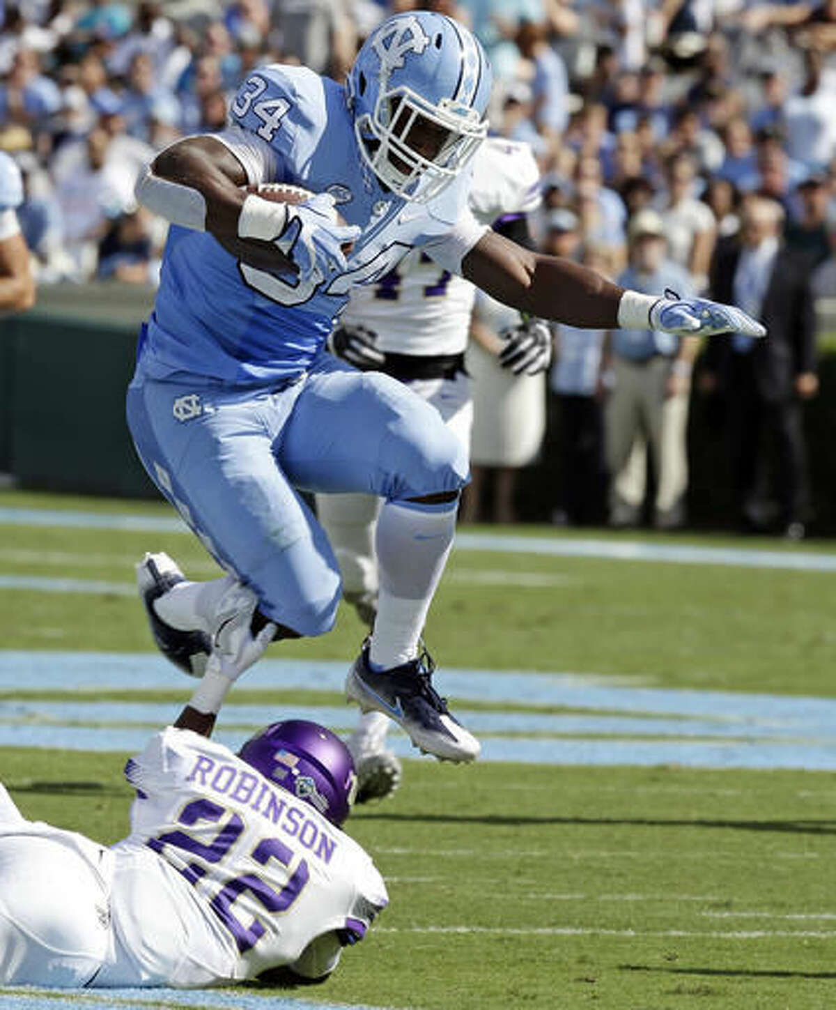 FILE - In this Sept. 17, 2016, file photo, North Carolina's Elijah Hood (34) jumps over James Madison's Rashad Robinson (22) during the first half of an NCAA college football game in Chapel Hill, N.C. North Carolina coach Larry Fedora said Wednesday, Oct. 2, 2016, he expects Hood to play this week at No. 16 Miami. Hood missed last week's 34-3 loss to Virginia Tech with a concussion. (AP Photo/Gerry Broome, File)