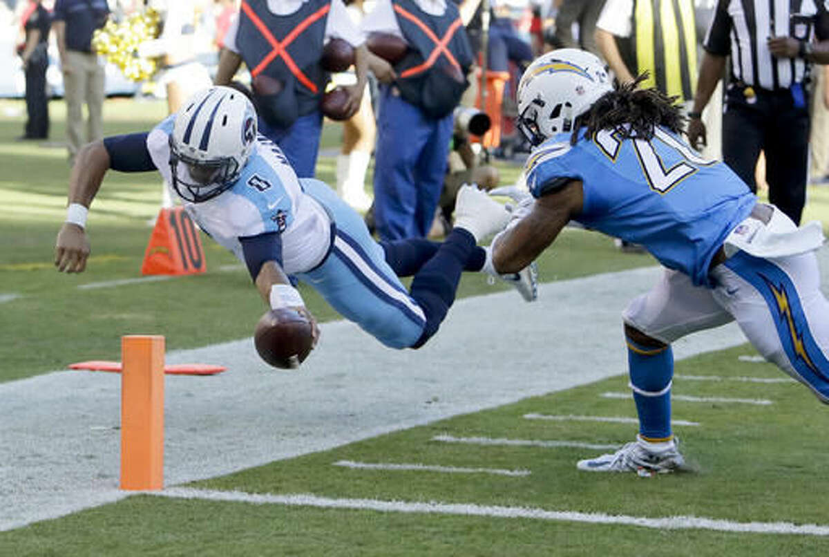 Tennessee Titans quarterback Marcus Mariota, left, dives into the end zone for a touchdown as San Diego Chargers free safety Dwight Lowery (20) defends during the second half of an NFL football game, Sunday, Nov. 6, 2016, in San Diego. (AP Photo/Rick Scuteri)
