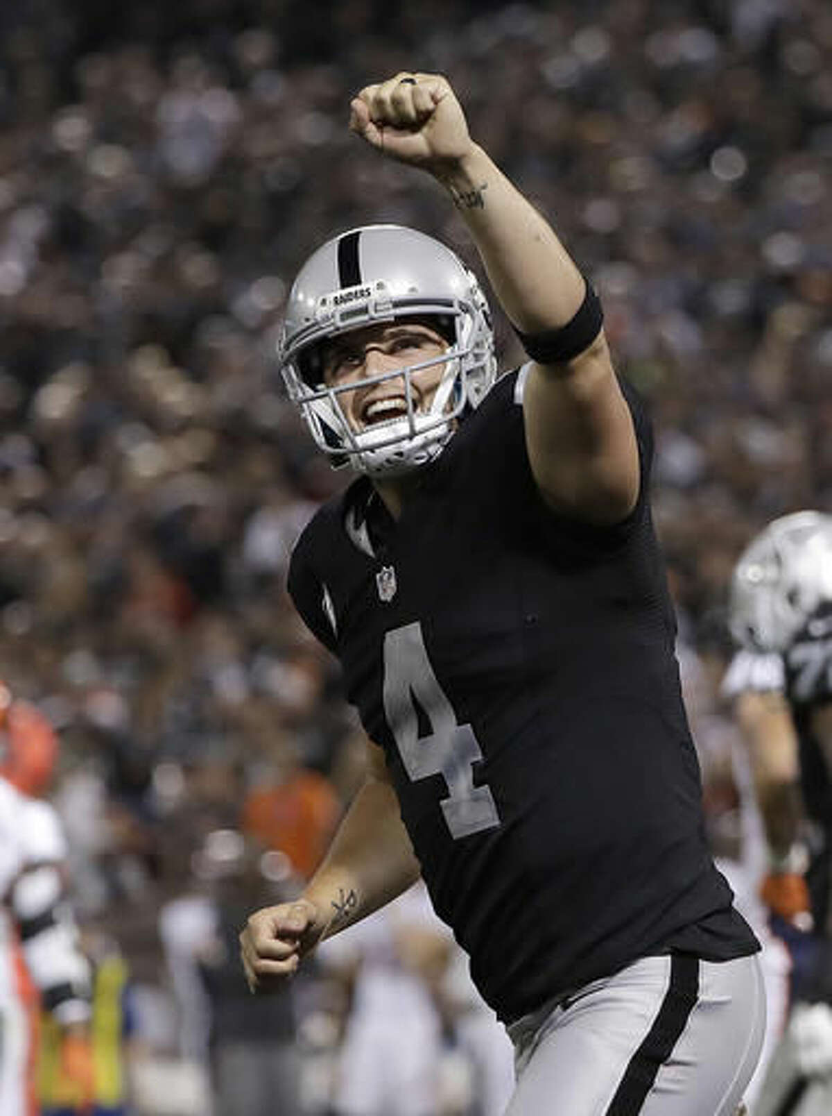 Oakland Raiders quarterback Derek Carr (4) celebrates after a touchdown run by Latavius Murray during the second half of an NFL football game against the Denver Broncos in Oakland, Calif., Sunday, Nov. 6, 2016. (AP Photo/Marcio Jose Sanchez)