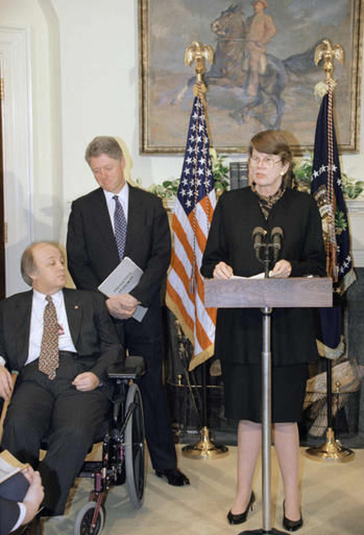 FILE - In this Tuesday, Feb. 28, 1995, file photo, Attorney General Janet Reno, accompanied by President Bill Clinton and James Brady, speaks at the White House during a ceremony marking the one-year anniversary of the Brady handgun control law. Reno, the first woman to serve as U.S. attorney general and the epicenter of several political storms during the Clinton administration, has died early Monday, Nov. 7, 2016. She was 78. (AP Photo/Wilfredo Lee, File)