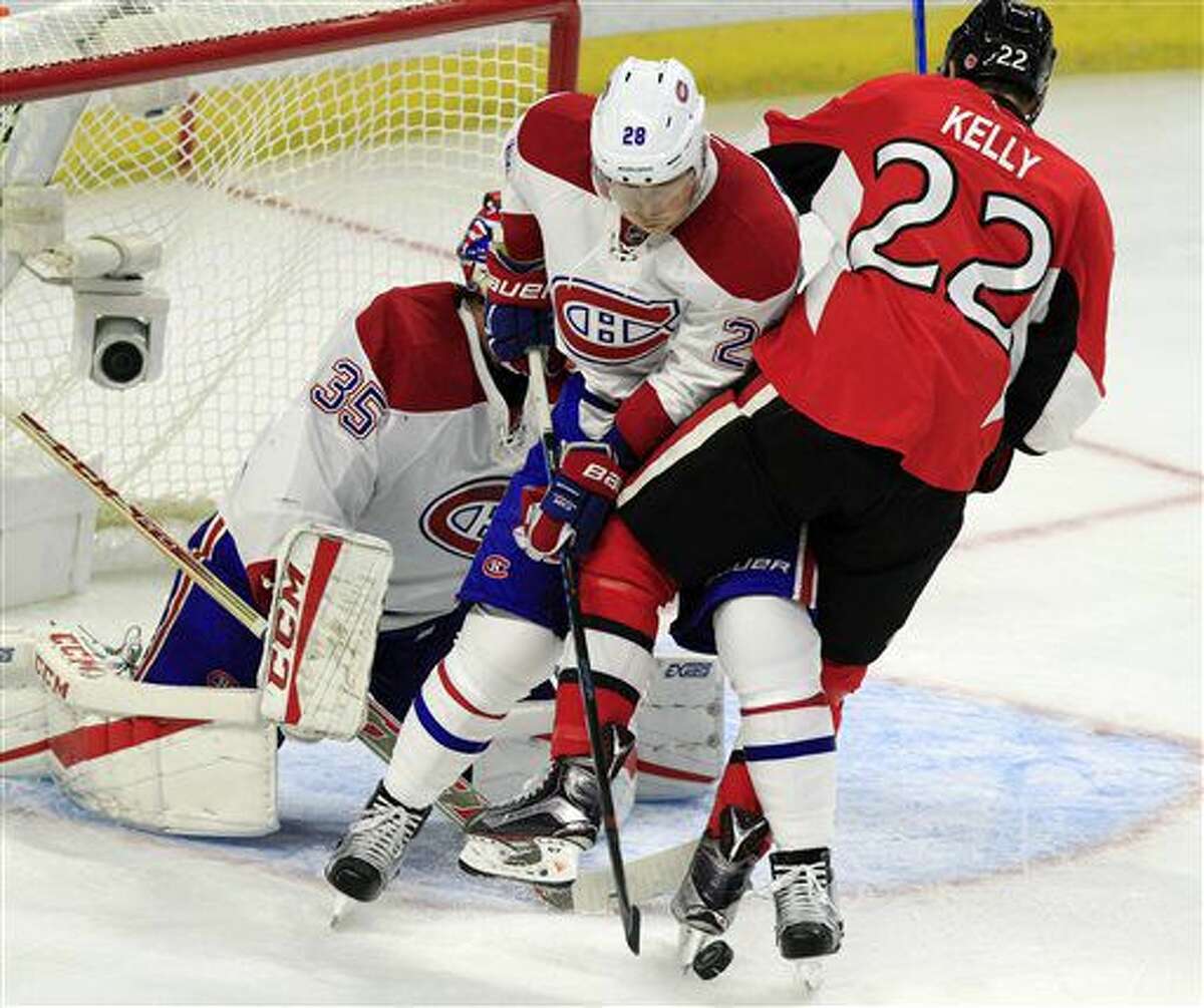 Montreal Canadiens' Nathan Beaulieu (28) checks Ottawa Senators' Chris Kelly (22) as he clears the puck from in front of the Canadiens' net during the first period of an NHL hockey game Saturday, Oct. 15, 2016, in Ottawa, Ontario. (Fred Chartrand/The Canadian Press via AP)