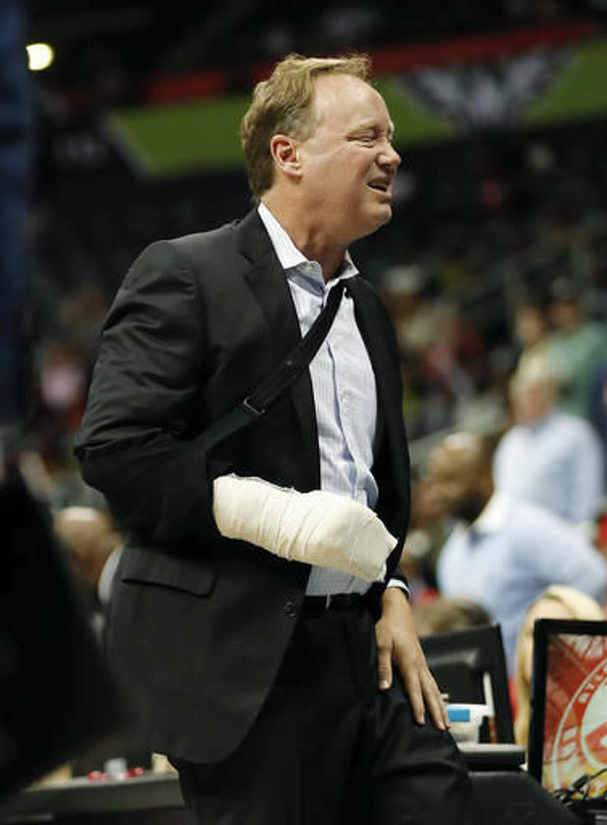 Atlanta Hawks coach Mike Budenholzer holds his leg and grimaces after he was run over on the sideline during the first half of the team's preseason NBA basketball game against the New Orleans Pelicans on Tuesday, Oct. 18, 2016, in Atlanta. Budenholzer, who was already nursing an injured hand, left the game. (AP Photo/John Bazemore)