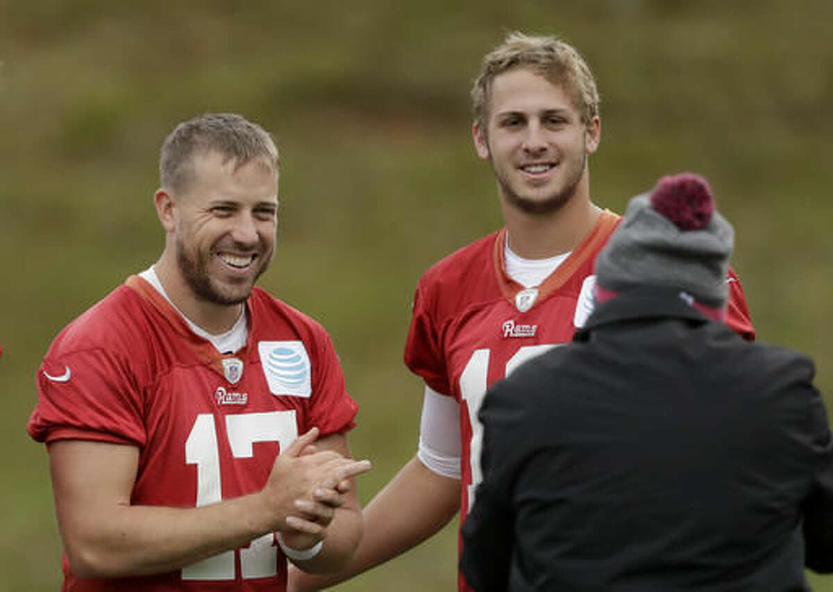 Los Angeles Rams quarterbacks Case Keenum, left, and Jared Goff pose for photographs together at the end of a practice session at Pennyhill Park Hotel in Bagshot, England, Thursday, Oct. 20, 2016. The Los Angeles Rams are due to play the New York Giants at Twickenham stadium in London on Sunday in a regular season NFL game. (AP Photo/Matt Dunham)