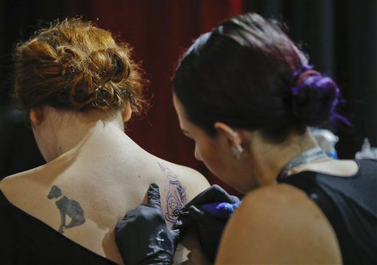 In this picture taken on Sunday, Oct. 16, 2016, a woman gets a tattoo during the International Tattoo Convention Bucharest 2016 in Bucharest, Romania. More than 100 tattoo and piercing artists brought their skills and art to a three-day convention in the Romanian capital.(AP Photo/Vadim Ghirda)