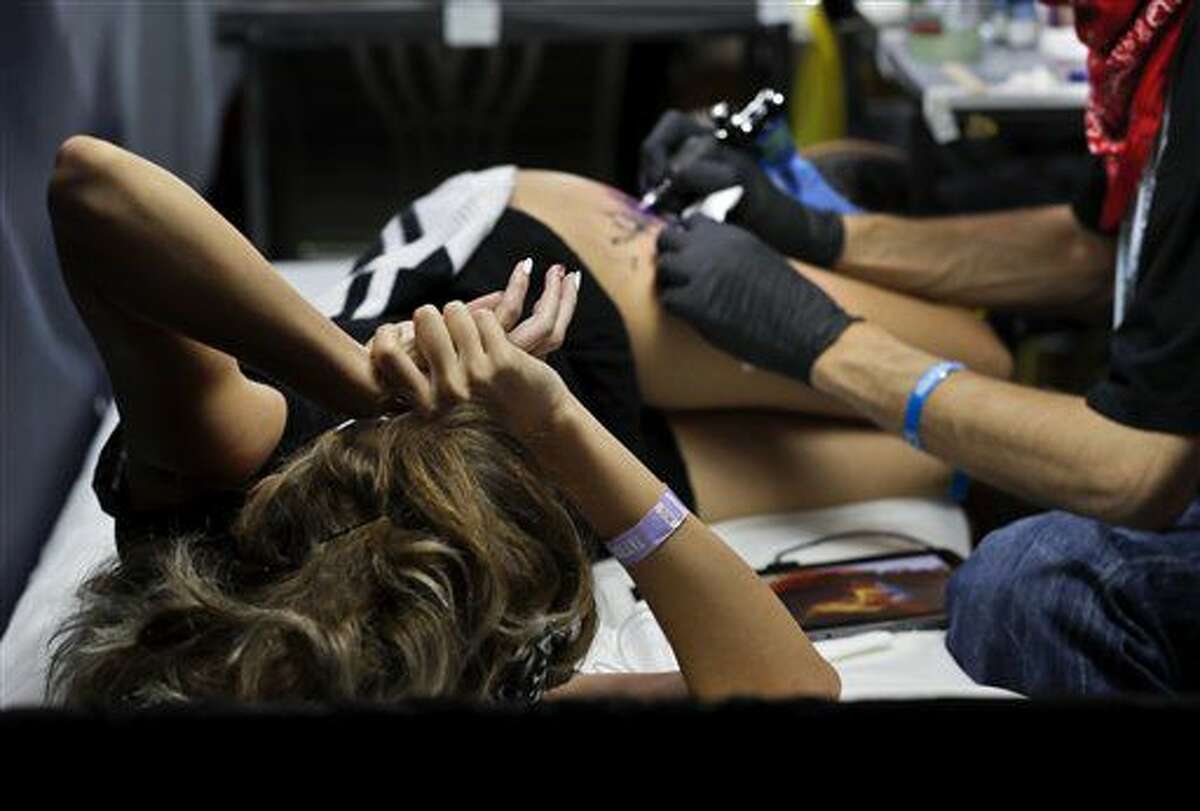 In this picture taken on Sunday, Oct. 16, 2016, a woman gets a tattoo during the International Tattoo Convention Bucharest 2016 in Bucharest, Romania. AP Photo/Vadim Ghirda)