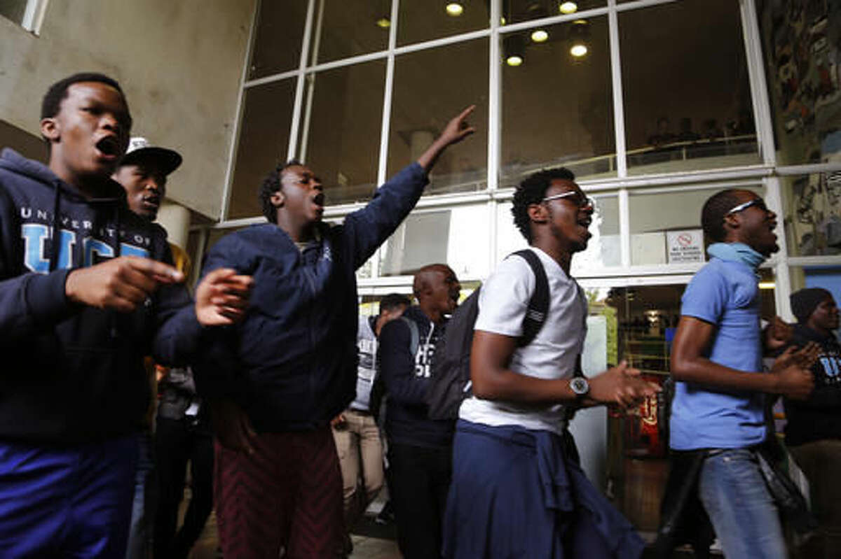 Students from the University of Cape Town protest for free education by disrupting classes in Cape Town, South Africa, Tuesday, Oct. 18, 2016. The University of Cape Town re-opened Monday after closing because of security concerns, but police were on campus and used a stun grenade to disperse protesters outside a university building. Another building was evacuated because of vandalism by protesters who tossed sewage in the corridors, said the statement. (AP Photo/Schalk van Zuydam)