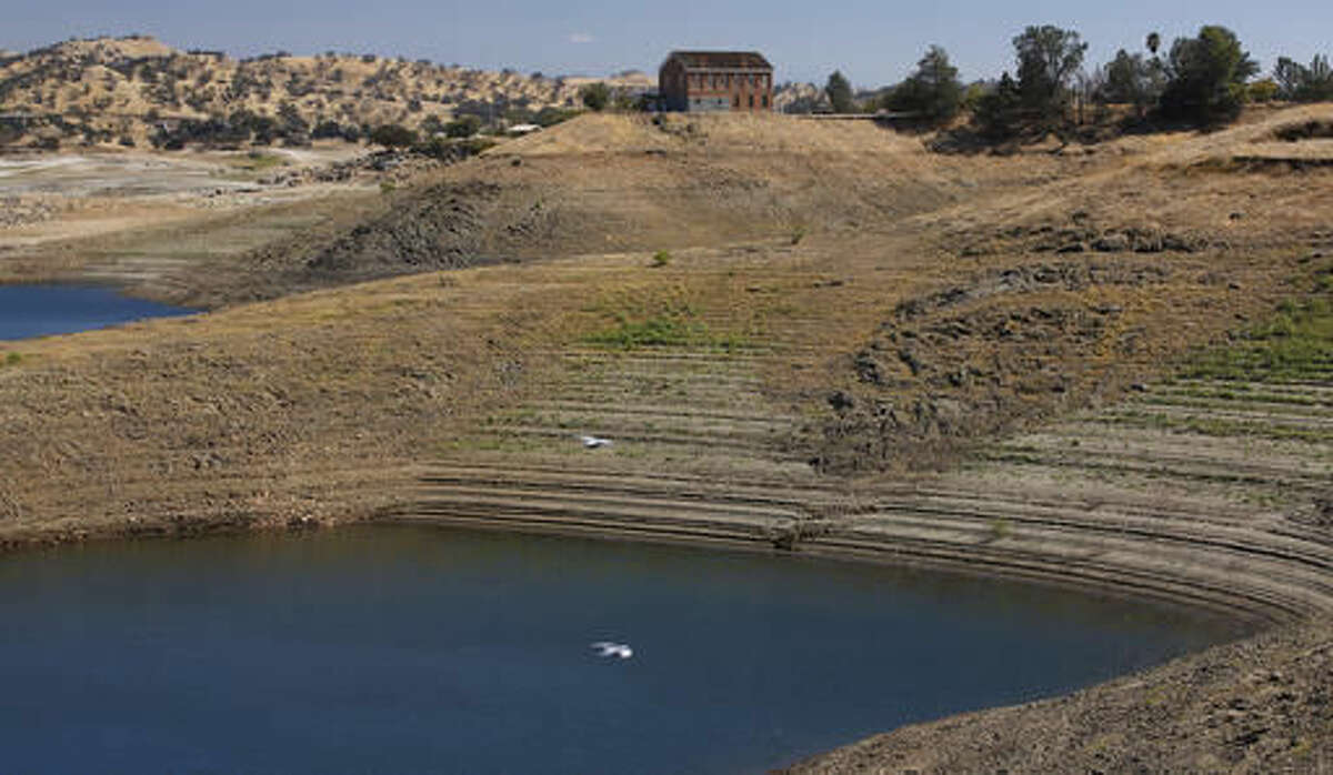 In this Oct. 5, 2016, photo, the old Fresno County Superior Courthouse stands near a depleted water reservoir during a tour of the Millerton Lake area which feeds the San Joaquin River in Friant, Calif. A decade ago, environmentalists and the federal government agreed to revive a 150-mile stretch of California's second-longest river, an ambitious effort aimed at allowing salmon to again swim up to the Sierra Nevada foothills to spawn. (AP Photo/Gary Kazanjian)