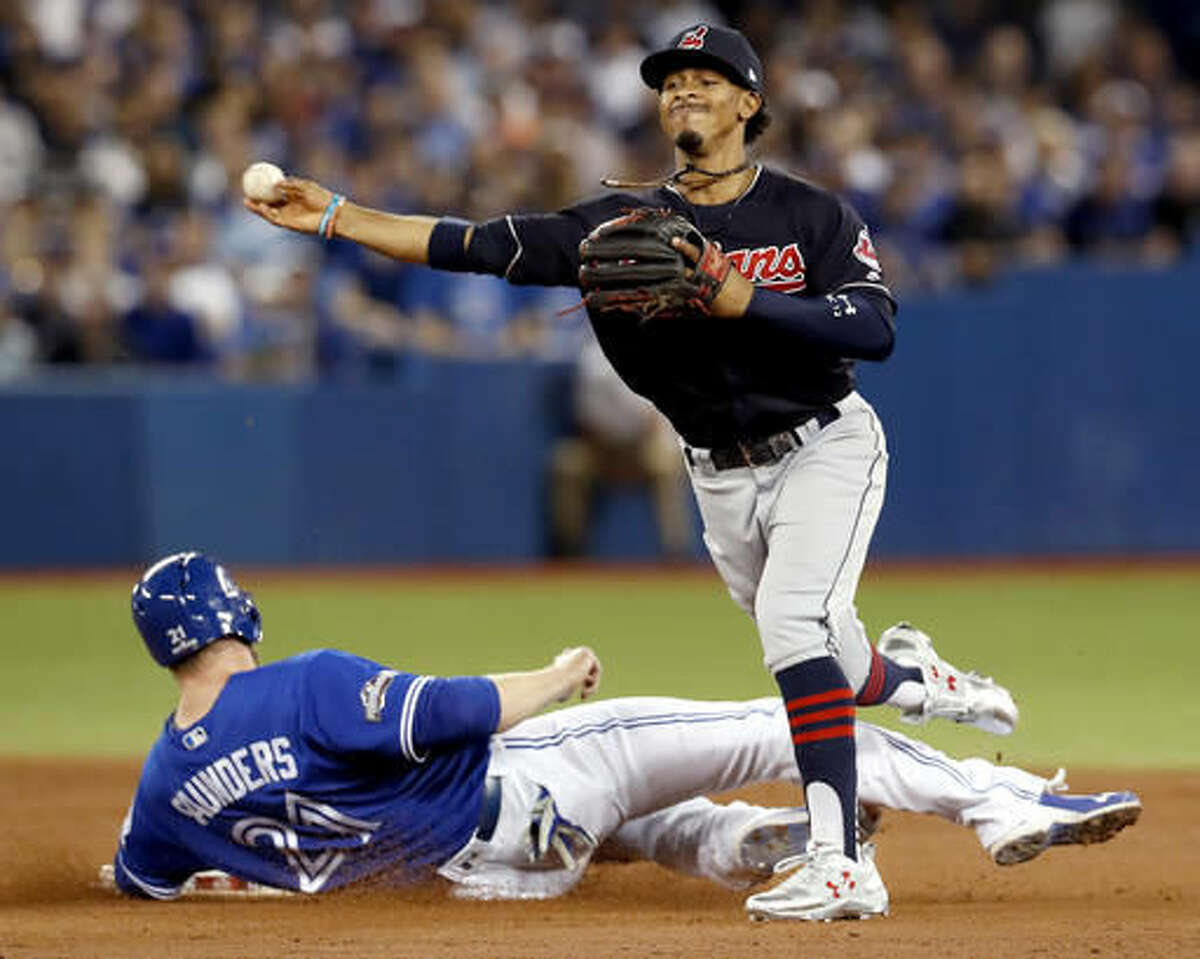 FILE- In this Tuesday Oct. 18, 2016, file photo, Cleveland Indians shortstop Francisco Lindor, right, forces Toronto Blue Jays' Michael Saunders out at second, but, fails to throws Ezequiel Carrera out at first during the second inning in Game 4 of baseball's American League Championship Series in Toronto. A leader in the clubhouse and on the field, Cleveland's 22-years-old exuberant shortstop has blossomed in this postseason will now showcase his immense talents in the World Series. (Mark Blinch/The Canadian Press via AP, File)