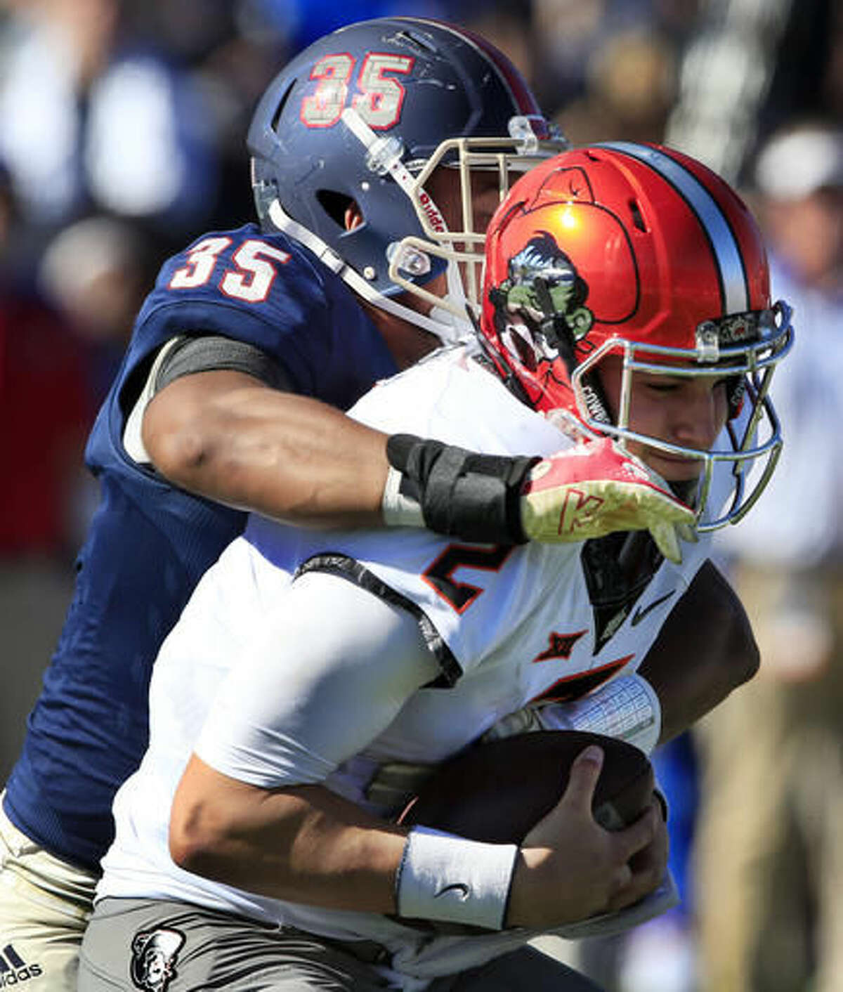 Oklahoma State quarterback Mason Rudolph (2) is sacked by Kansas defensive end Anthony Olobia (35) during the second half of an NCAA college football game in Lawrence, Kan., Saturday, Oct. 22, 2016. (AP Photo/Orlin Wagner)