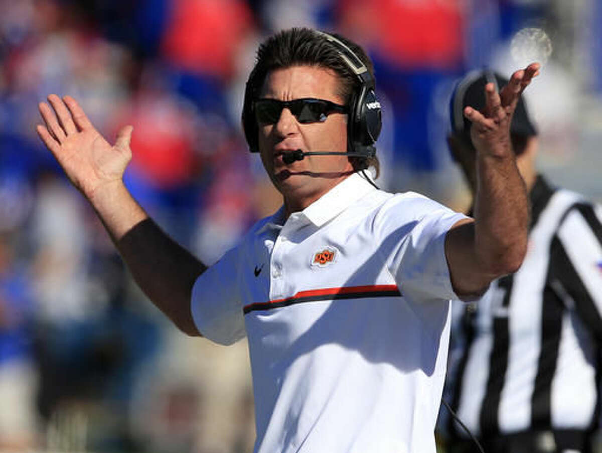Oklahoma State head coach Mike Gundy questions a call during the first half of an NCAA college football game against Kansas in Lawrence, Kan., Saturday, Oct. 22, 2016. (AP Photo/Orlin Wagner)