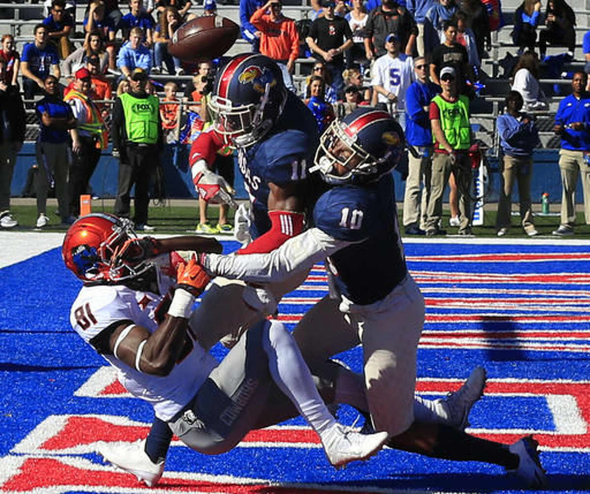 Kansas linebacker Mike Lee (11) and cornerback Marnez Ogletree (10) break up a pass intended for Oklahoma State wide receiver Jhajuan Seales (81) during the first half of an NCAA college football game in Lawrence, Kan., Saturday, Oct. 22, 2016. (AP Photo/Orlin Wagner)