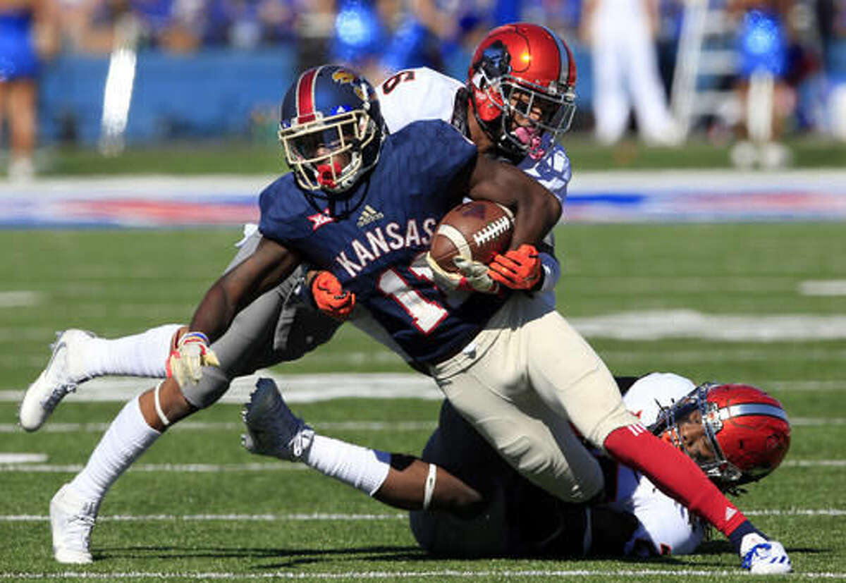 Kansas wide receiver Steven Sims Jr. (11) is tackled by Oklahoma State linebacker Jordan Burton (20) and cornerback Ashton Lampkin (6) during the second half of an NCAA college football game in Lawrence, Kan., Saturday, Oct. 22, 2016. (AP Photo/Orlin Wagner)