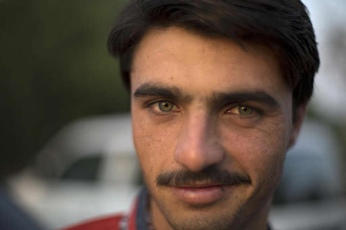 Pakistani tea vendor Arshad Khan, 18, poses for a photograph at a market where he sells tea in Islamabad, Pakistan, Friday, Oct. 21, 2016. Khan, who saw his life change overnight after a picture of him at work went viral, said Friday he was totally unaware of social media until recently when boys and girls suddenly started thronging a flea market in Islamabad to take selfies with him.(AP Photo/B.K. Bangash)