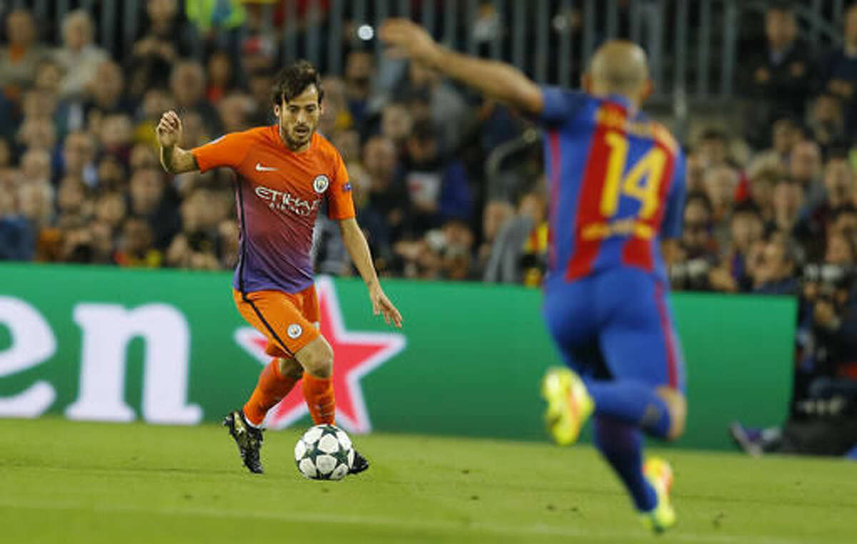 Manchester City's David Silva runs with the ball in front of Barcelona's Javier Mascherano during a Champions League, Group C soccer match between Barcelona and Manchester City, at the Camp Nou stadium in Barcelona, Wednesday, Oct. 19, 2016. (AP Photo/Francisco Seco)