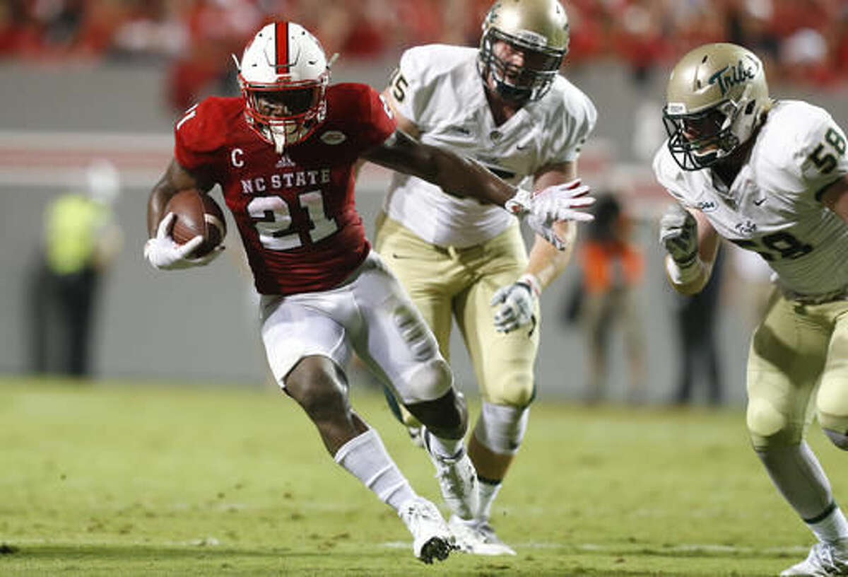FILE - In this Sept. 1, 2016, file photo, North Carolina State running back Matthew Dayes (21) carries as William & Mary defensive end Matt Ahola (58) closes in during an NCAA college football game in Raleigh, N.C. North Carolina State plays at Louisville this week. (Ethan Hyman/The News & Observer via AP, File)