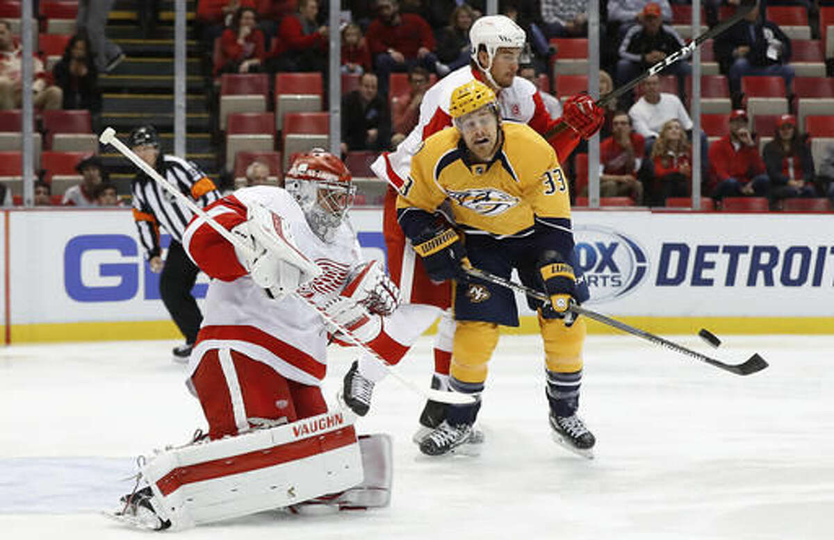 Detroit Red Wings defenseman Brendan Smith (2) checks Nashville Predators left wing Colin Wilson (33) as he waits for a rebound from a blocked shot by goalie Petr Mrazek (34) during the first period of an NHL hockey game Friday, Oct. 21, 2016, in Detroit. (AP Photo/Paul Sancya)