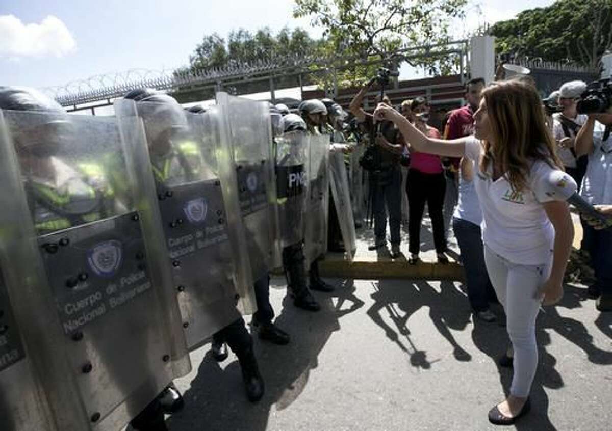 A university student confronts police standing guard during a protest demanding a recall referendum against Venezuela's President Nicolas Maduro, near the Central University of Venezuela (UCV) in Caracas, Venezuela, Friday, Oct. 21, 2016. Venezuela's electoral authority suspended a recall drive against Maduro on Thursday, less than a week before it was set to start, throwing the opposition's key campaign to oust the leader into further disarray. (AP Photo/Ariana Cubillos)
