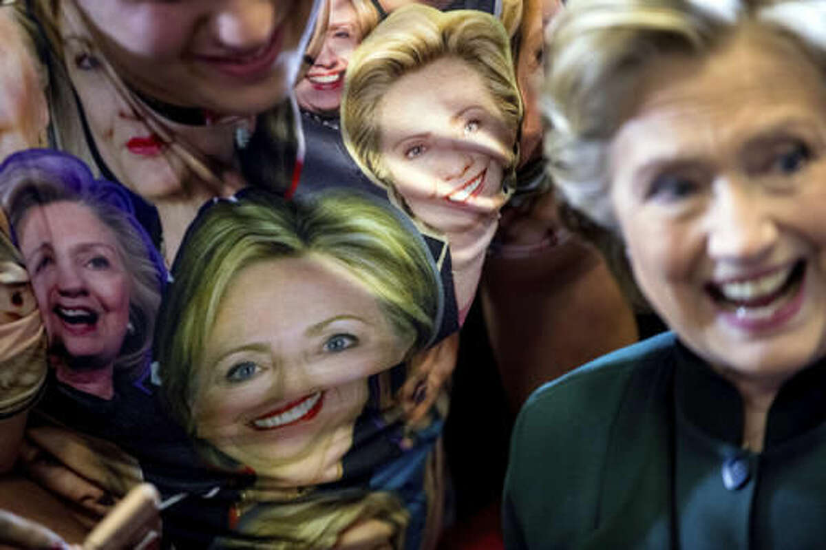 Democratic presidential candidate Hillary Clinton poses with a supporter who wears a shirt depicting her at a rally at Cuyahoga Community College in Cleveland, Friday, Oct. 21, 2016. (AP Photo/Andrew Harnik)