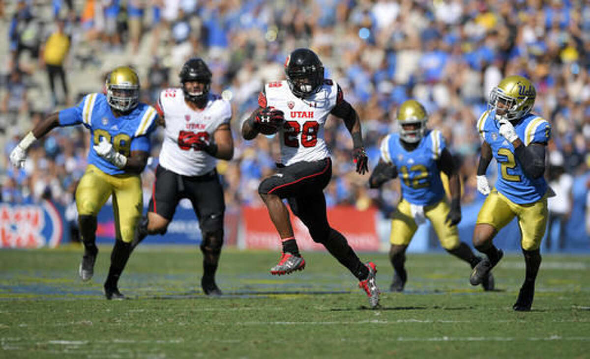 Utah running back Joe Williams, center, runs for a touchdown as UCLA defensive lineman Takkarist McKinley, left, linebacker Jayon Brown, second from left, and defensive back Jaleel Wadood, right, give chase along with Utah offensive tackle Sam Tevi during the first half of an NCAA college football game, Saturday, Oct. 22, 2016, in Pasadena, Calif. (AP Photo/Mark J. Terrill)