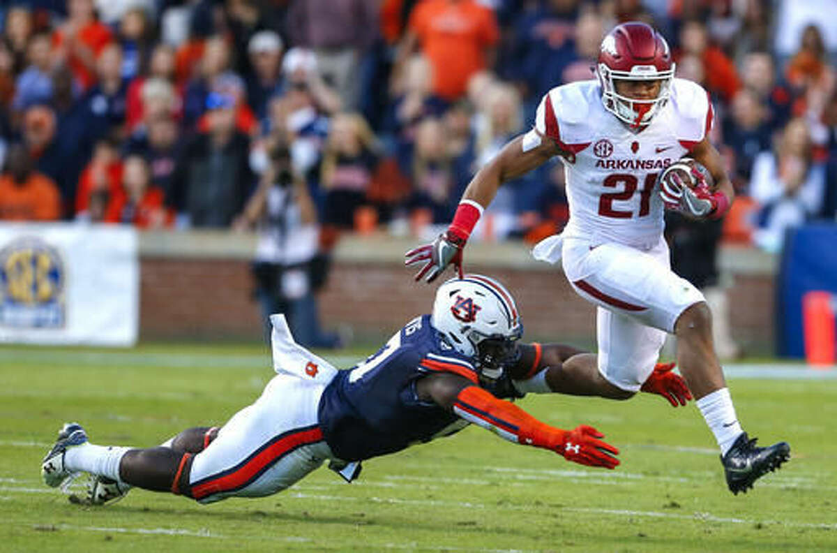 Arkansas running back Devwah Whaley (21) tries to elude the tackle of Auburn linebacker Deshaun Davis (57) during the first half of an NCAA college football game, Saturday, Oct. 22, 2016, in Auburn, Ala. (AP Photo/Butch Dill)