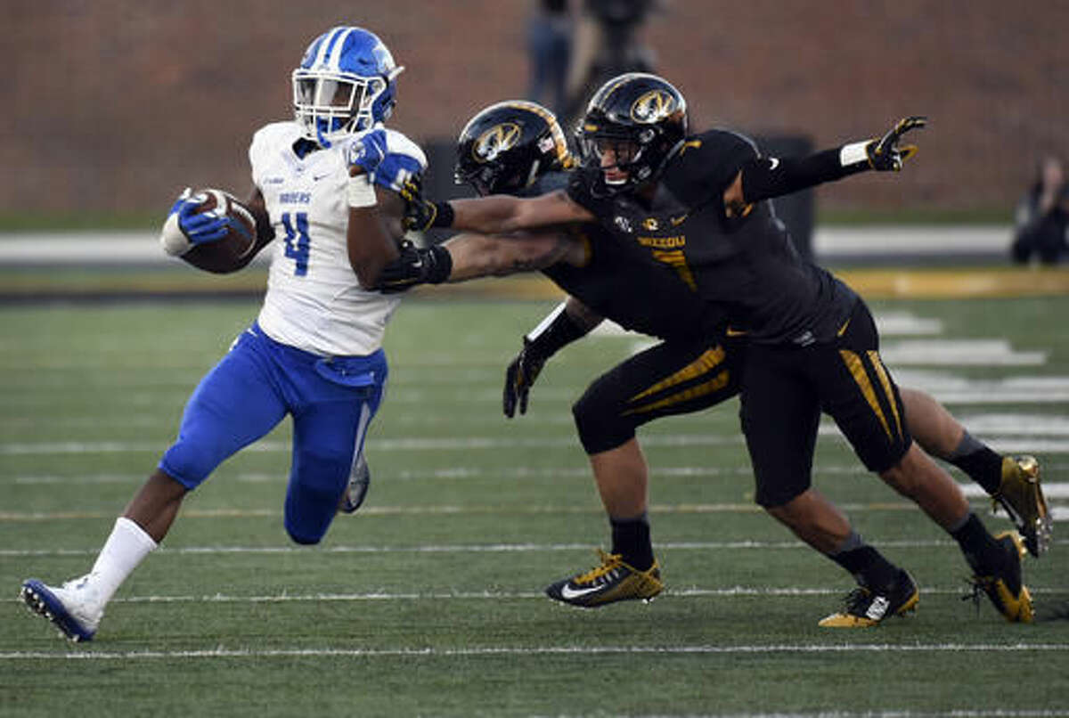 Middle Tennessee running back I'Tavius Mathers (4) slips past Missouri defenders Cale Garrett and Cam Hilton, right, during the second half of an NCAA college football game, Saturday, Oct. 22, 2016, in Columbia, Mo. (AP Photo/L.G. Patterson)