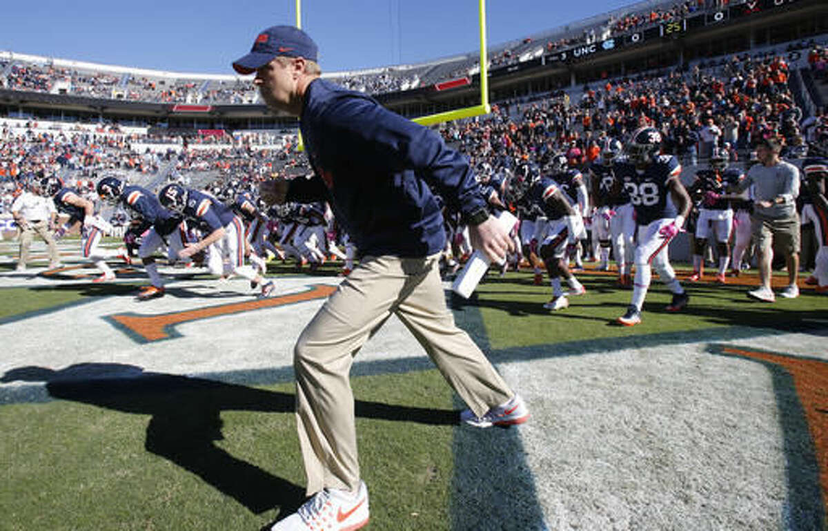 Virginia head coach Bronco Mendenhall leads his team onto the field prior to the start of an NCAA college football game between North Carolina and Virginia at Scott stadium in Charlottesville, Va., Saturday, Oct. 22, 2016. (AP Photo/Steve Helber)