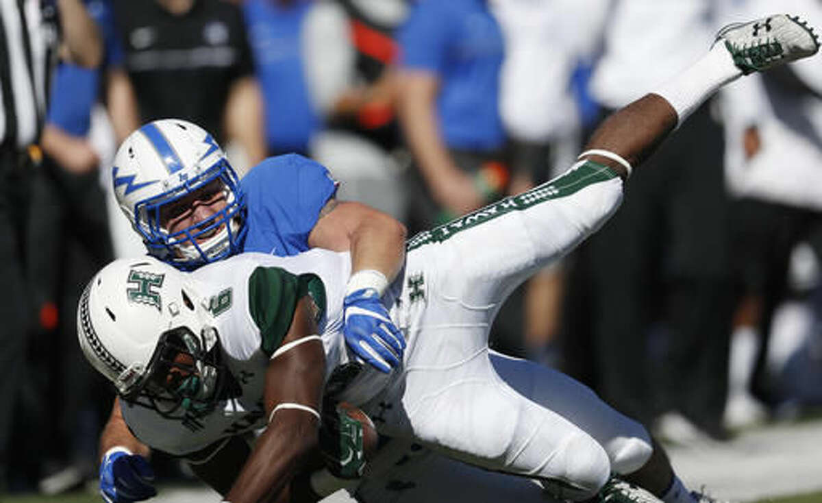 Hawaii running back Paul Harris, front, is tackled by Air Force linebacker Patrick Healy in the first half of an NCAA college football game, Saturday, Oct. 22, 2016, at Air Force Academy, Colo. (AP Photo/David Zalubowski)