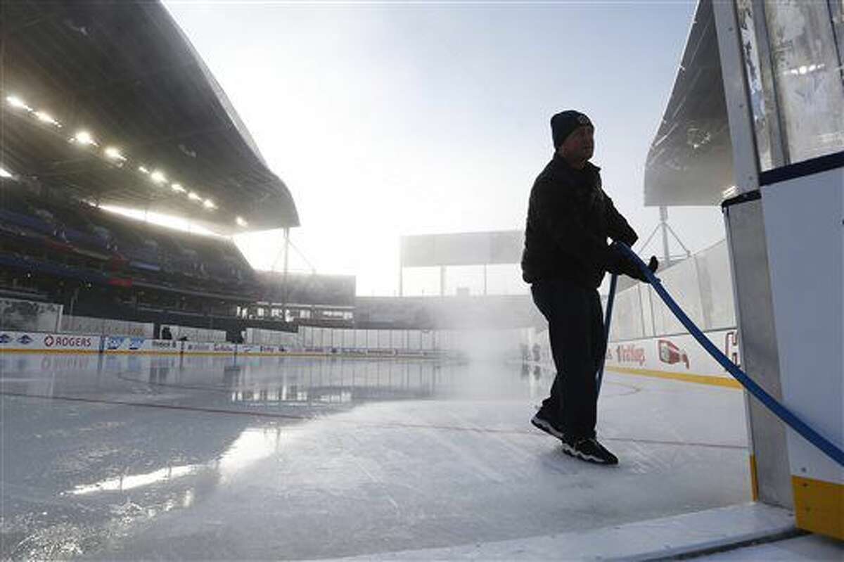 An ice maker puts the finishing coat on at Investors Group Field, home of the 2016 NHL's Heritage Classic hockey games in Winnipeg, Manitoba, Saturday, Oct. 22, 2016. Winnipeg will host games between current and alumni players from the Winnipeg Jets and Edmonton Oilers this weekend. (John Woods/The Canadian Press via AP)