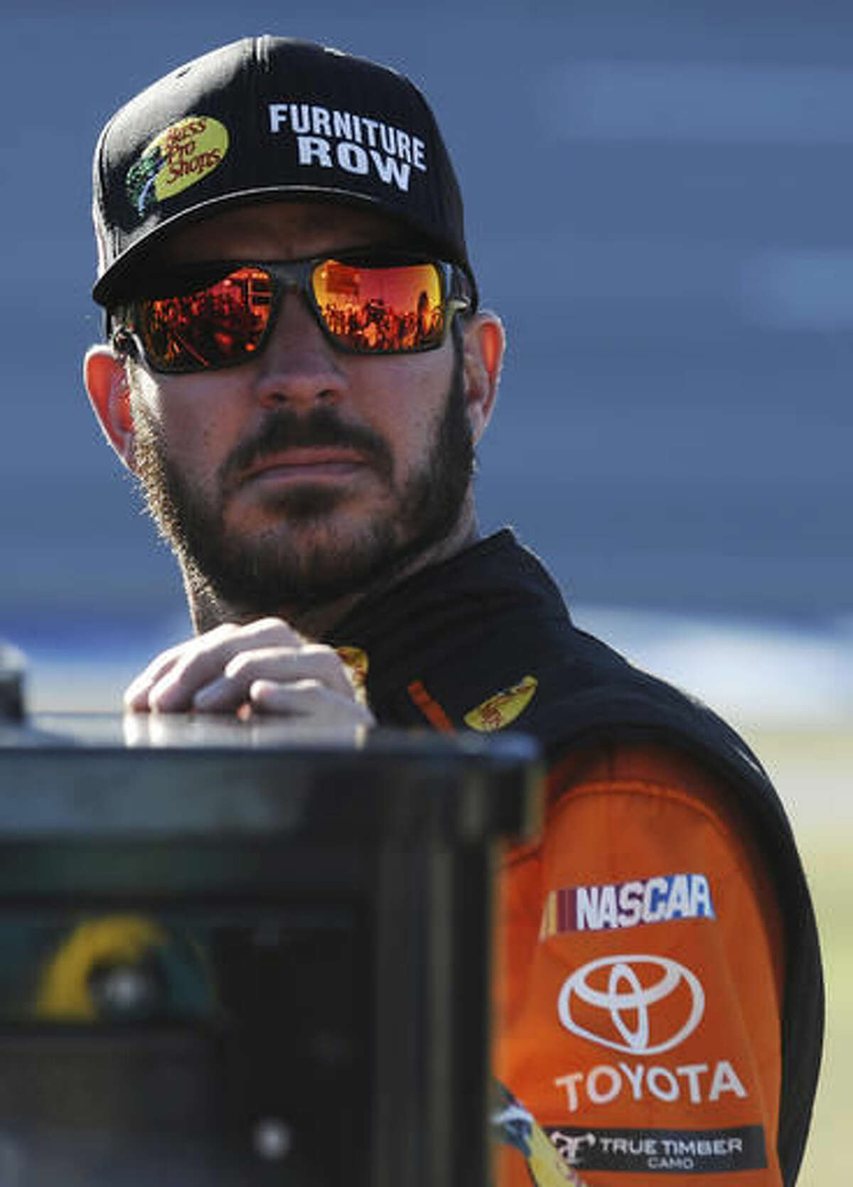Martin Truex Jr. stands on pit road before qualifying for Sunday's NASCAR Sprint Cup auto race at Talladega Superspeedway on Saturday, Oct. 22, 2016, in Talladega, Ala. (AP Photo/Rainier Ehrhardt)
