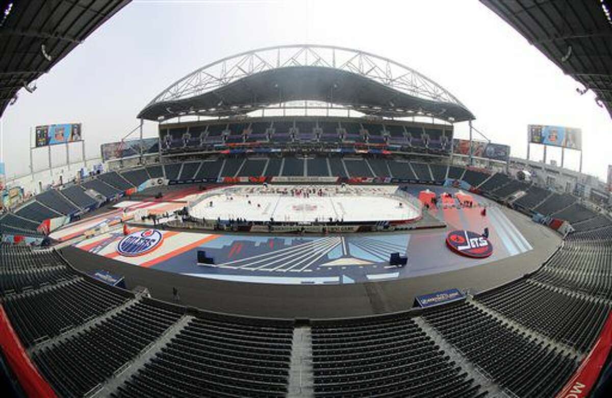 In this photo taken with a fish-eye lens, the Edmonton Oilers practice at Investors Group Field for the NHL Heritage Classic outdoor hockey game in Winnipeg, Manitoba, Saturday, Oct. 22, 2016. The Oilers taken on the Winnipeg Jets Sunday. (Trevor Hagan/The Canadian Press via AP)
