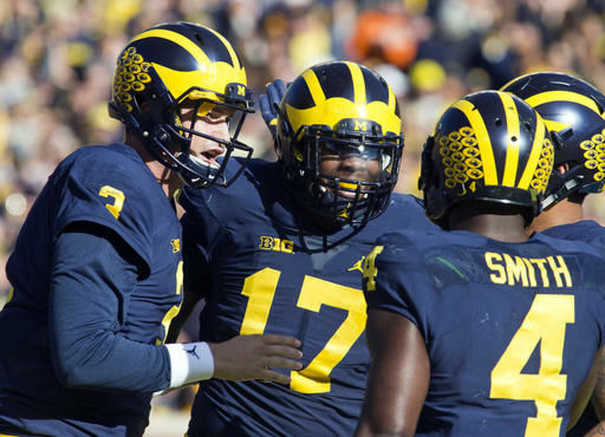Michigan quarterback Wilton Speight, left, celebrates a touchdown with tight end Tyrone Wheatley (17) and running back De'Veon Smith (4) in the first quarter of an NCAA college football game against Illinois at Michigan Stadium in Ann Arbor, Mich., Saturday, Oct. 22, 2016. (AP Photo/Tony Ding)