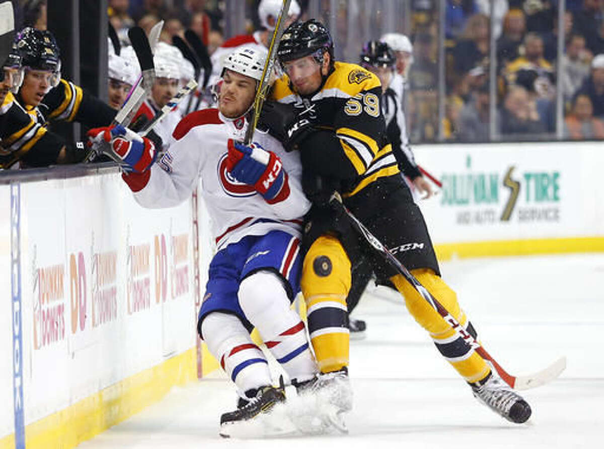 Montreal Canadiens' Andrew Shaw is checked into the boards by Boston Bruins' Tim Schaller (59) during the first period of an NHL hockey game in Boston on Saturday, Oct. 22, 2016. (AP Photo/Winslow Townson)