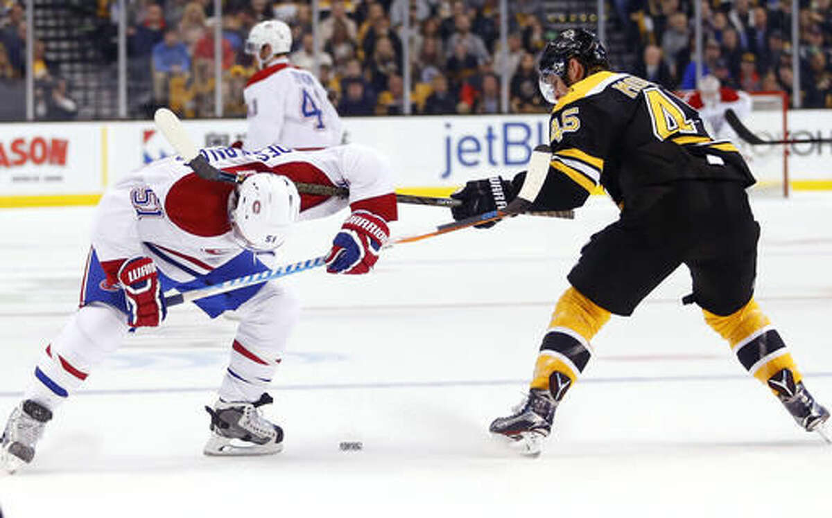 Boston Bruins defenseman Joe Morrow (45) brings his stick down on Montreal Canadiens' David Desharnais for a penalty during the first period of an NHL hockey game in Boston on Saturday, Oct. 22, 2016. (AP Photo/Winslow Townson)