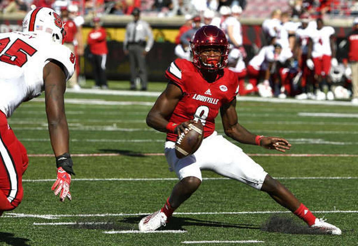Louisville's Lamar Jackson, (8), attempts to avoid North Carolina State's Tyrone Riley (95) during the second half of their NCAA college football game, Saturday, Oct. 22, 2016, in Louisville, Ky. Louisville won 54-13. (AP Photo/Timothy D. Easley)