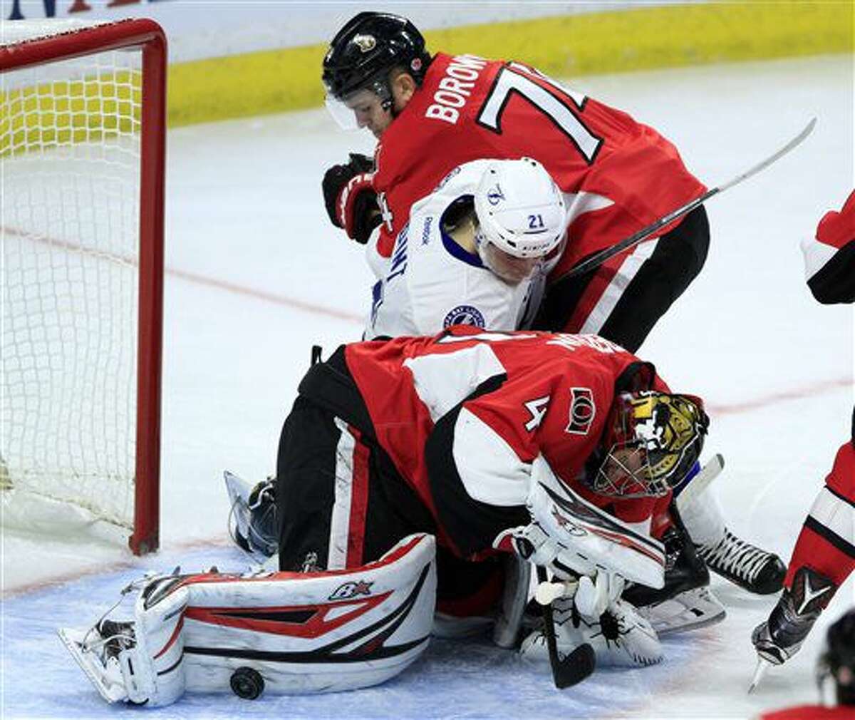 Ottawa Senators goaltender Craig Anderson (41) looks for the puck as teammate Mark Borowiecki (74) checks Tampa Bay Lighting's Brayden Point (21) during the second period of an NHL hockey game Saturday, Oct. 22, 2016, in Ottawa, Ontario. (Fred Chartrand/The Canadian Press via AP)