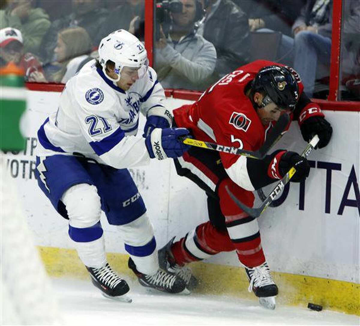 Ottawa Senators' Cody Ceci (5) and Tampa Bay Lighting's Brayden Point (21) vie for the puck during the first period of an NHL hockey game Saturday, Oct. 22, 2016, in Ottawa, Ontario. (Fred Chartrand/The Canadian Press via AP)