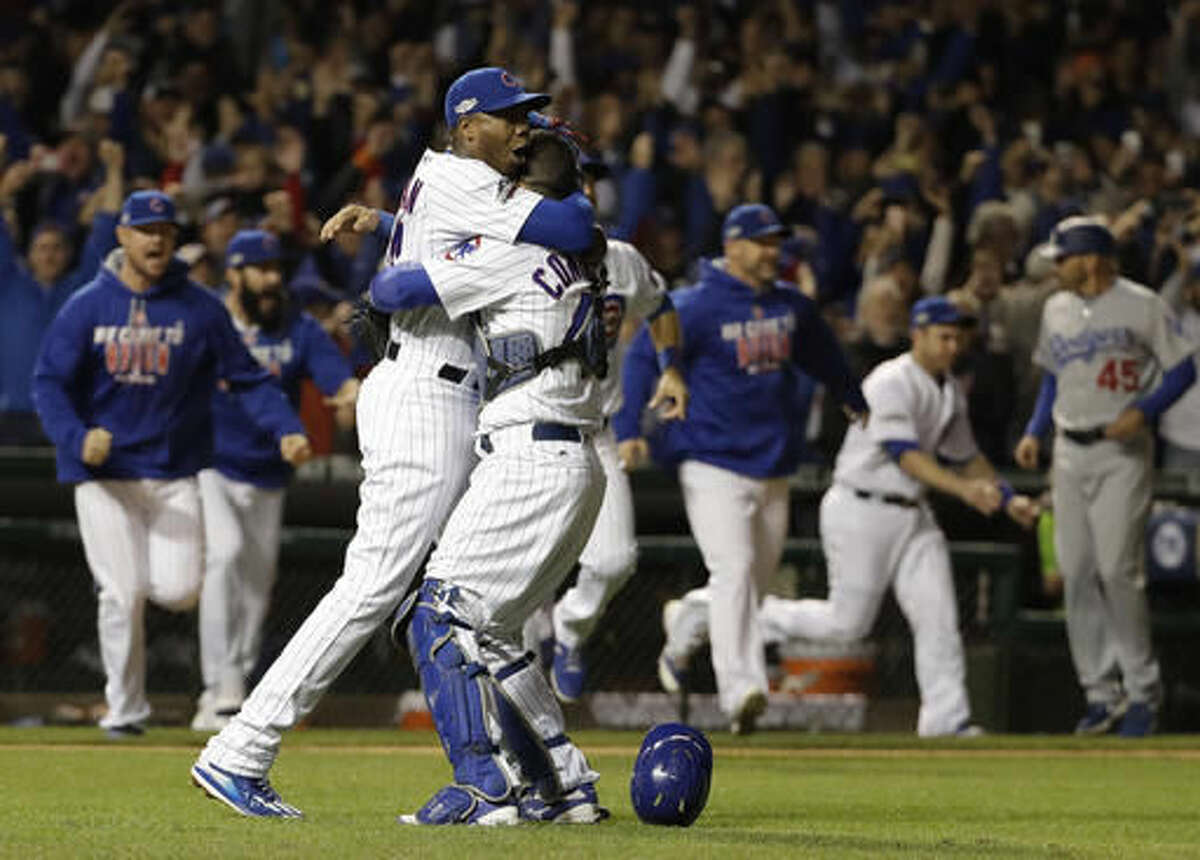 Chicago Cubs catcher Willson Contreras and relief pitcher Aroldis Chapman (54) celebrate after Game 6 of the National League baseball championship series against the Los Angeles Dodgers Saturday, Oct. 22, 2016, in Chicago. The Cubs won 5-0 to win the series and advance to the World Series against the Cleveland Indians. (AP Photo/David J. Phillip)