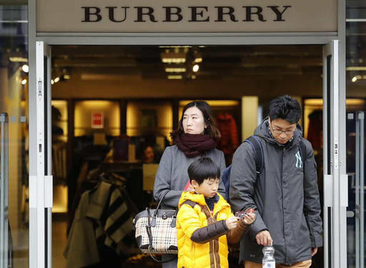 People leave a Burberry store in London, Friday, Oct. 21, 2016. At the moment, the price is right in Britain, where the decision to leave the European Union has led to a sharp drop in the pound. That’s proving a bonanza for luxury shoppers with foreign currency to spend. (AP Photo/Frank Augstein)