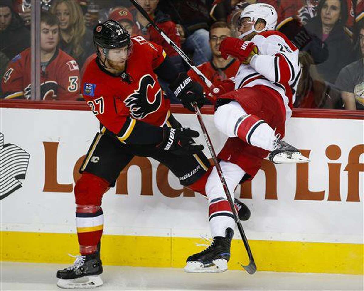 Carolina Hurricanes' Viktor Stalberg, right, from Sweden, is checked by Calgary Flames' Dougie Hamilton during the second period of an NHL hockey game, Thursday, Oct. 20, 2016 in Calgary, Alberta. (Jeff McIntosh/The Canadian Press via AP)