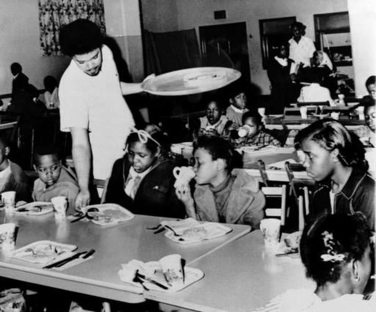 File - In this April 16, 1969 file photo, Bill Whitfield, member of the Black Panther chapter in Kansas City, serves free breakfast to children before they go to school. Hundreds of former Black Panthers from around the world are expected to gather in Oakland, California, for a four-day conference that started Thursday, Oct. 20, 2016. The Panthers emerged from the gritty city 50 years ago, declaring a new party dedicated to defending African-Americans against police brutality and protecting their rights. (AP Photo/William P. Straeter, File)