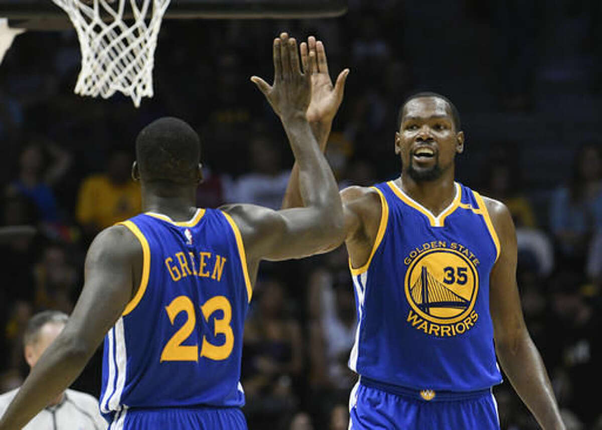 Golden State Warriors forward Kevin Durant (35) high-fives Draymond Green (23) after scoring during the second half of an NBA preseason basketball game against the Los Angeles Lakers on Wednesday, Oct. 19, 2016, in San Diego. (AP Photo/Denis Poroy)