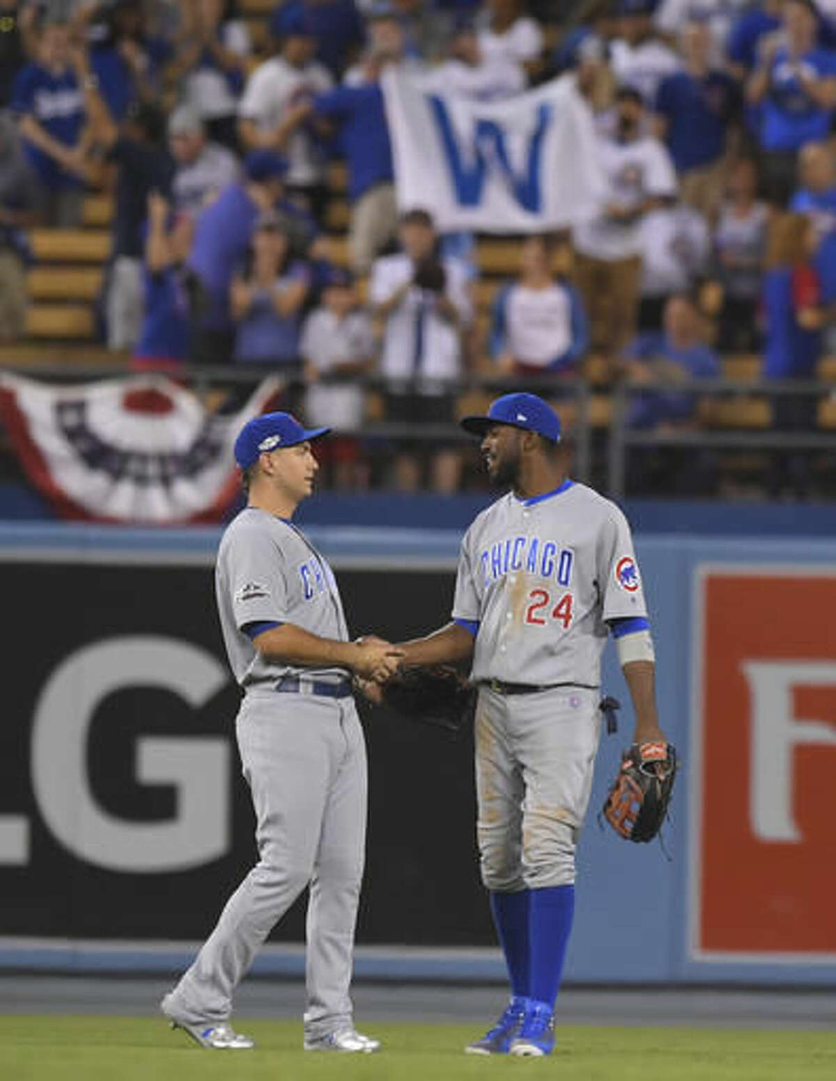 Chicago Cubs' Albert Almora Jr. and Dexter Fowler celebrate after Game 5 of the National League baseball championship series against the Los Angeles Dodgers Thursday, Oct. 20, 2016, in Los Angeles. The Cubs won 8-4 to take a 3-2 lead in the series. (AP Photo/Mark J. Terrill)