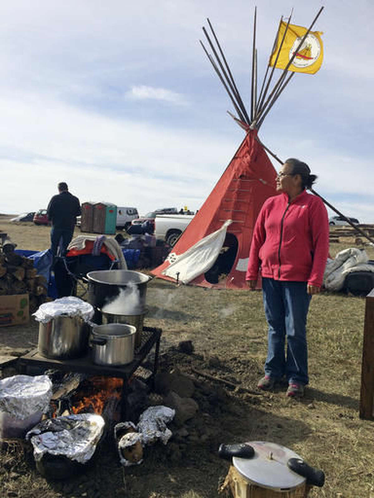 Mary Young Bear, of Tama, Iowa, cooks buffalo and potatoes over a campfire Monday, Oct. 24, 2016, at the Dakota Access oil pipeline protest in southern North Dakota. The long-running dispute over the Dakota Access oil pipeline expanded to private land recently purchased by the pipeline builders, with protesters who say the area rightfully belongs to Native Americans setting up camp and vowing to stay put until the project is stopped. (AP Photo/Blake Nicholson)