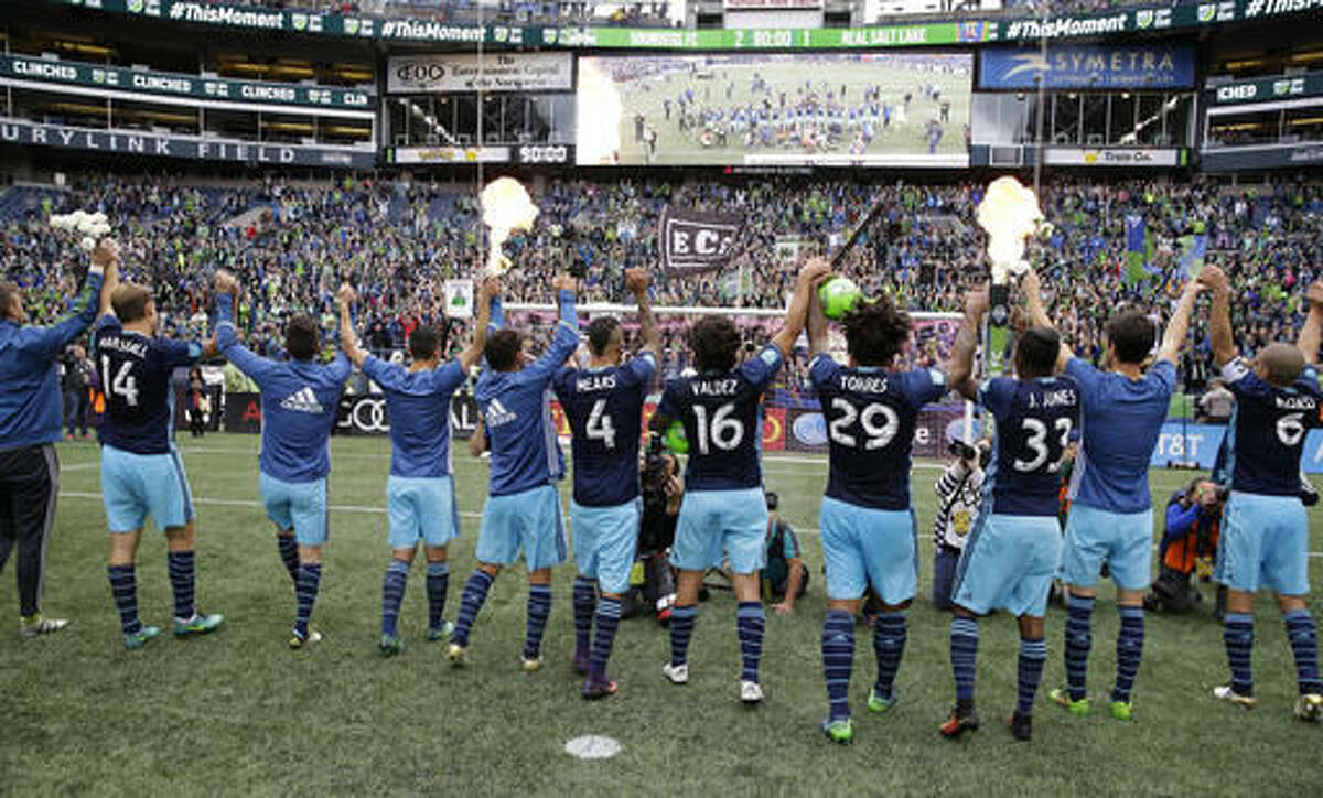 Seattle Sounders players celebrate as fire effects go off after the Sounders beat Real Salt Lake 2-1 in an MLS soccer match, Sunday, Oct. 23, 2016, in Seattle. The win clinches a spot in the playoffs for the Sounders. (AP Photo/Ted S. Warren)
