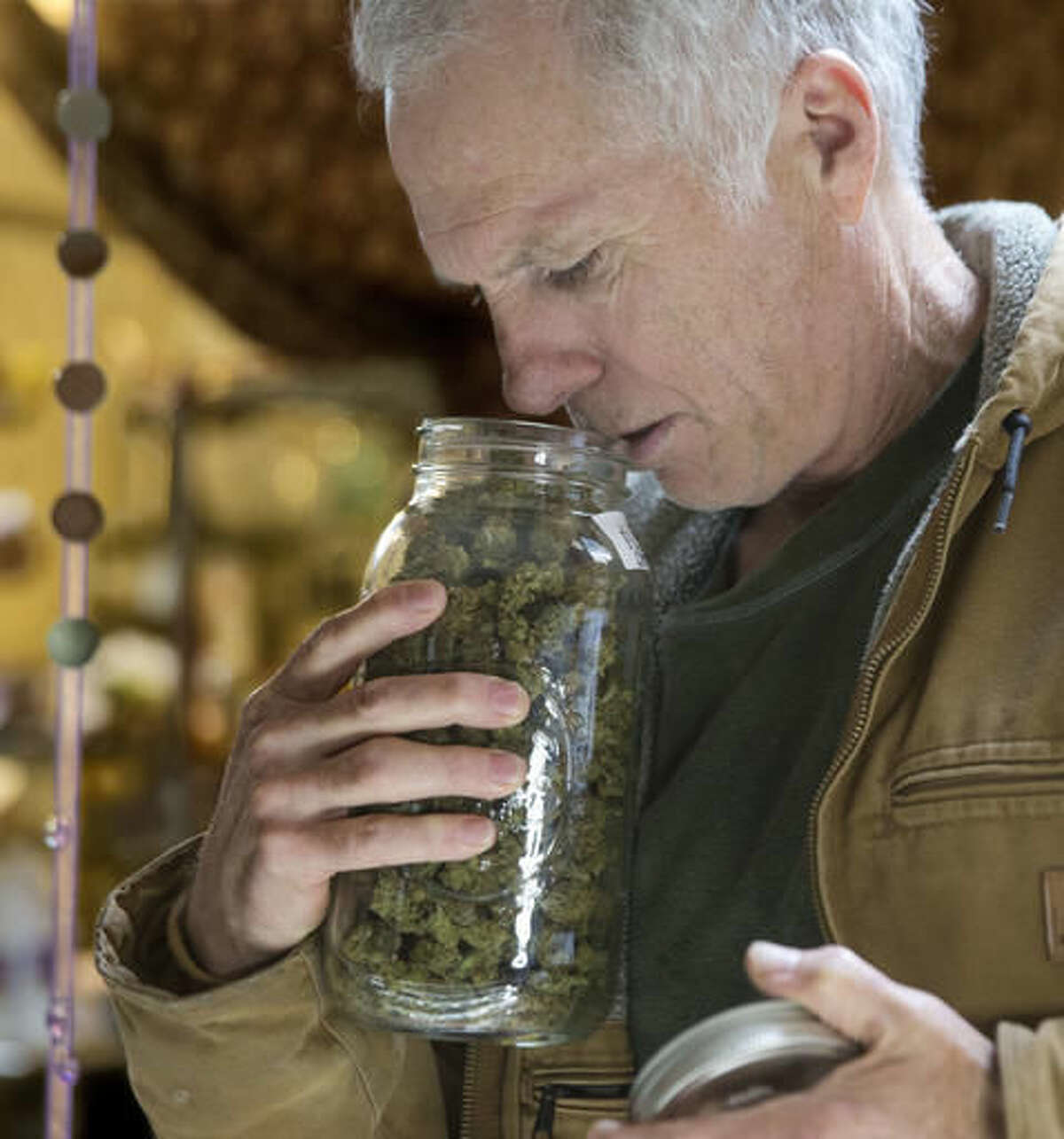 In this Thursday, Oct. 13, 2016 photo, Tim Blake checks the aroma of a jar of medical marijuana at his dispensary near Laytonville, Calif. Blake supports the passage of Proposition 64, the November ballot initiative which would legalize the recreational use of marijuana, saying it's the next big step for an industry emerging from the shadows. (AP Photo/Rich Pedroncelli)