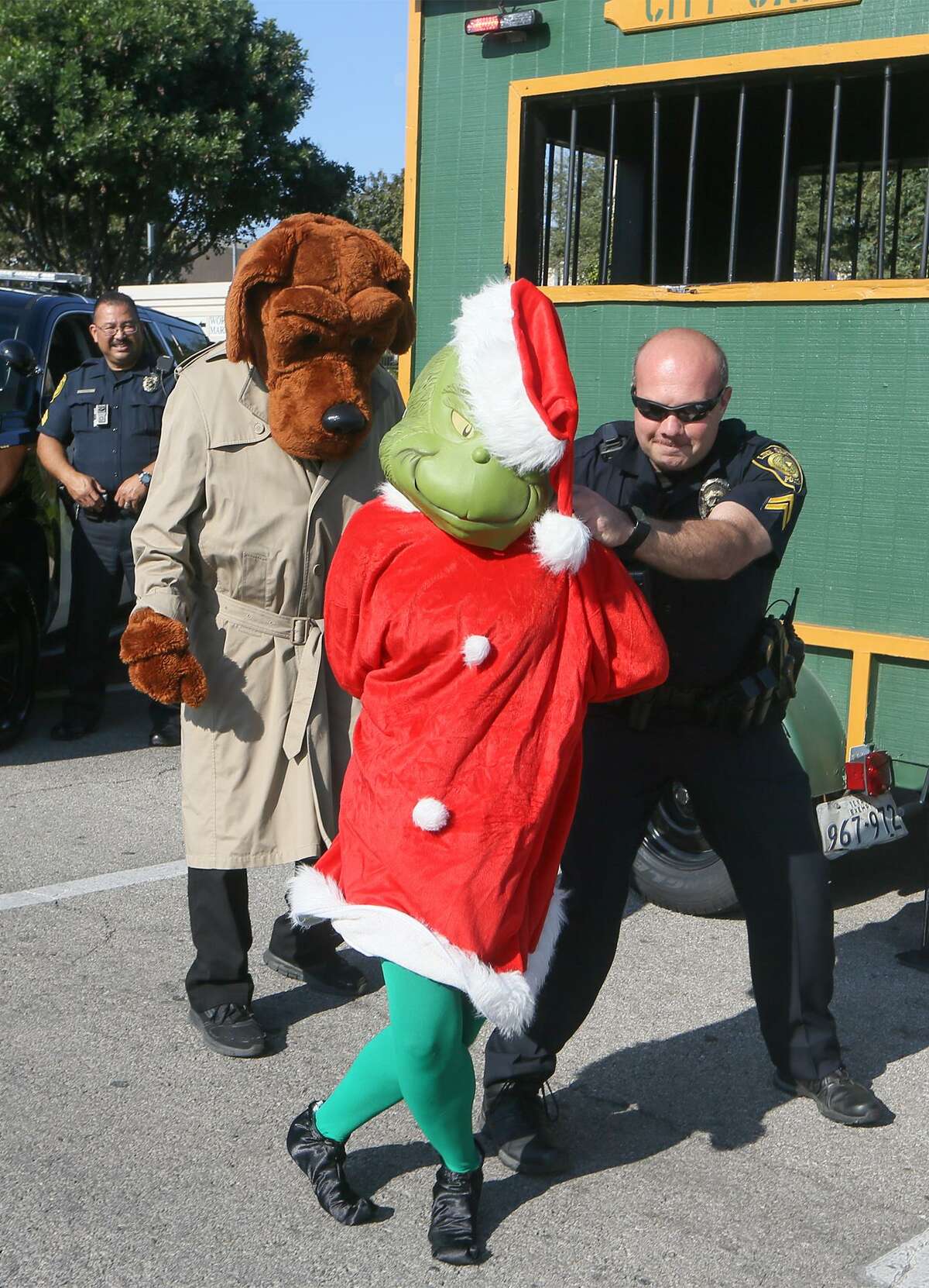 Cpl. William Feldtmose with the Live Oak Police Department arrests the Grinch with the help of McGruff the Crime Dog as police officers from Live Oak, Selma and Universal city kicked off the annual holiday safe shopping season with Operation Grinch 2016 in the Forum Shopping Center parking lot on Friday, Nov. 18, 2016. MARVIN PFEIFFER/ mpfeiffer@express-news.net