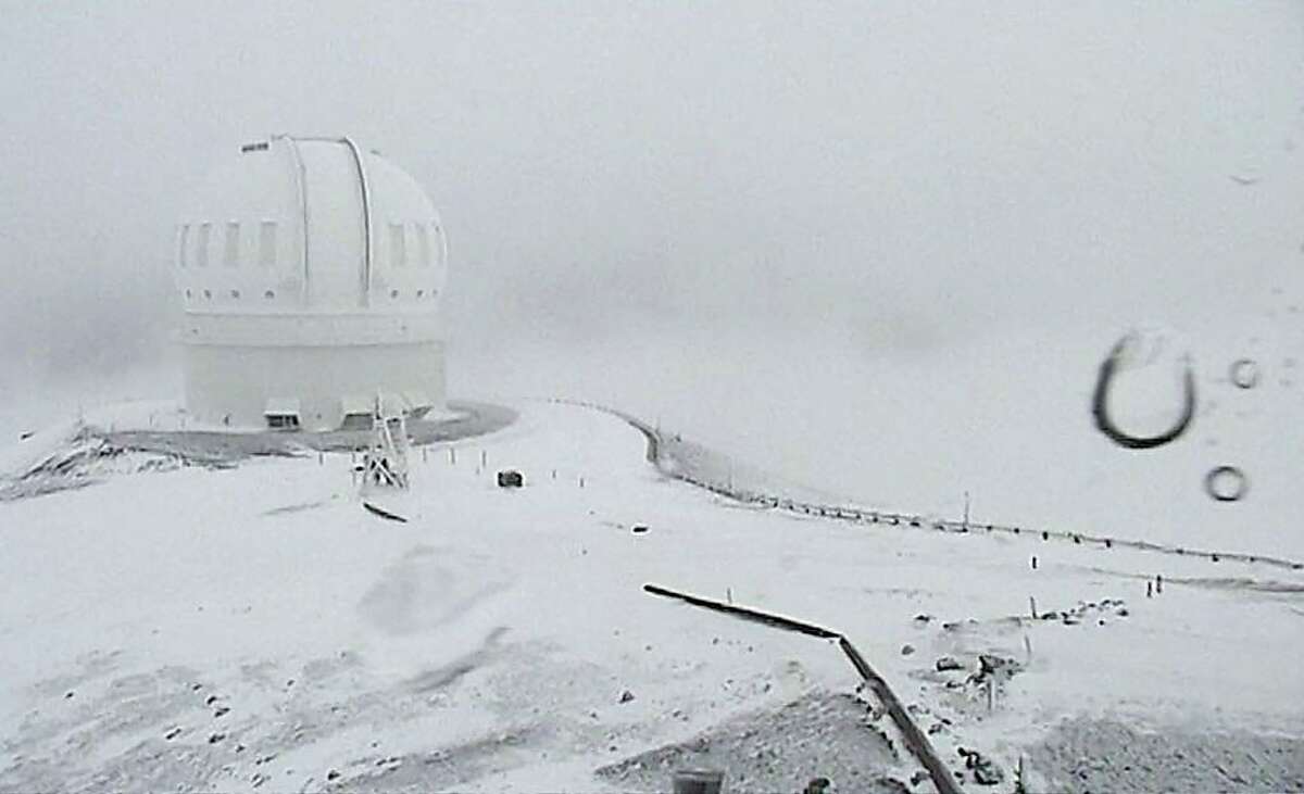 In this image from webcam video provided by Canada-France-Hawaii Telescope, the CFHT telescope on the summit of Mauna Kea on Hawaii's Big Island is covered in snow on Thursday, Dec. 1, 2016. The National Weather Service in Honolulu has issued a winter storm warning for the summits of Hawaii's Big Island as wind and snow engulf the high peaks.