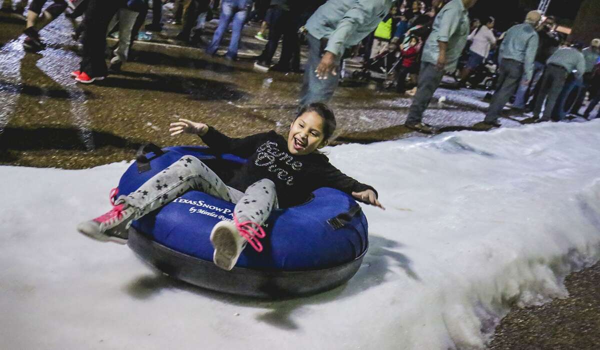 Chloe Tovar reacts as she sleds down a snow slope during the 2016 Navidad Fest.